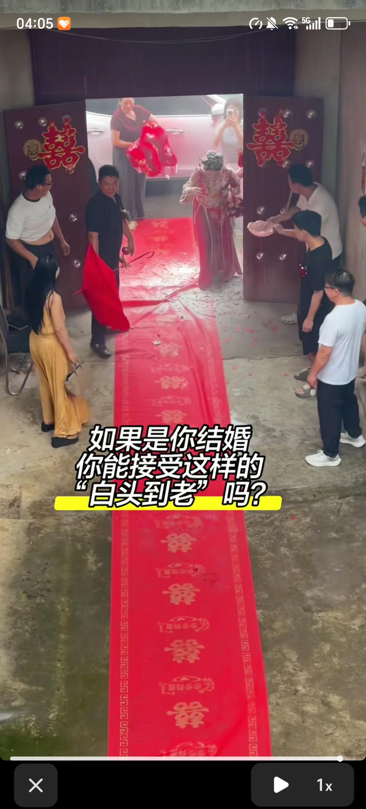 新郎新娘打着红伞下车，到了新郎的家门口后，早就准备好的两个男子一个负责夺走新郎手