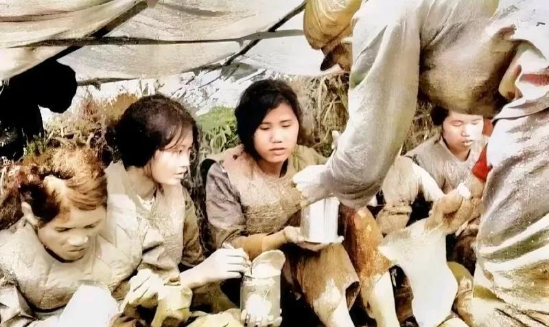 1979年，对越自卫反击战中，一名战士正在给抓获的越军女兵发放罐头。这些女兵十分