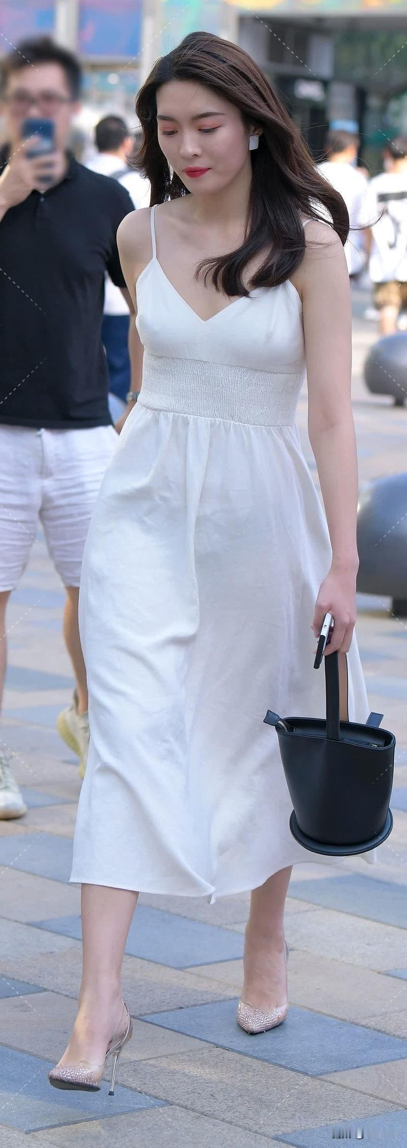 优雅漫步，白色连衣裙与高跟鞋的完美搭配，尽显都市女性魅力。