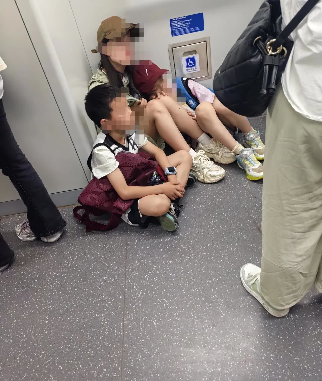 在地铁上，上来了母子三人，他们看见里边座位都坐满了人，于是就在车厢的角落里找个地