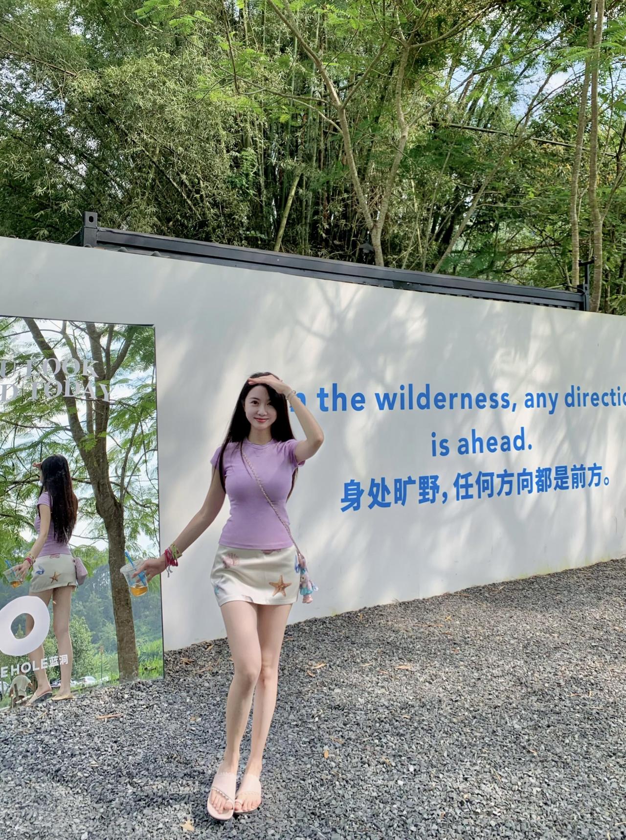 在这片绿意盎然的天地间，她静坐，与自然对话无言。瀑布轻吟，溪水潺，绿荫下，