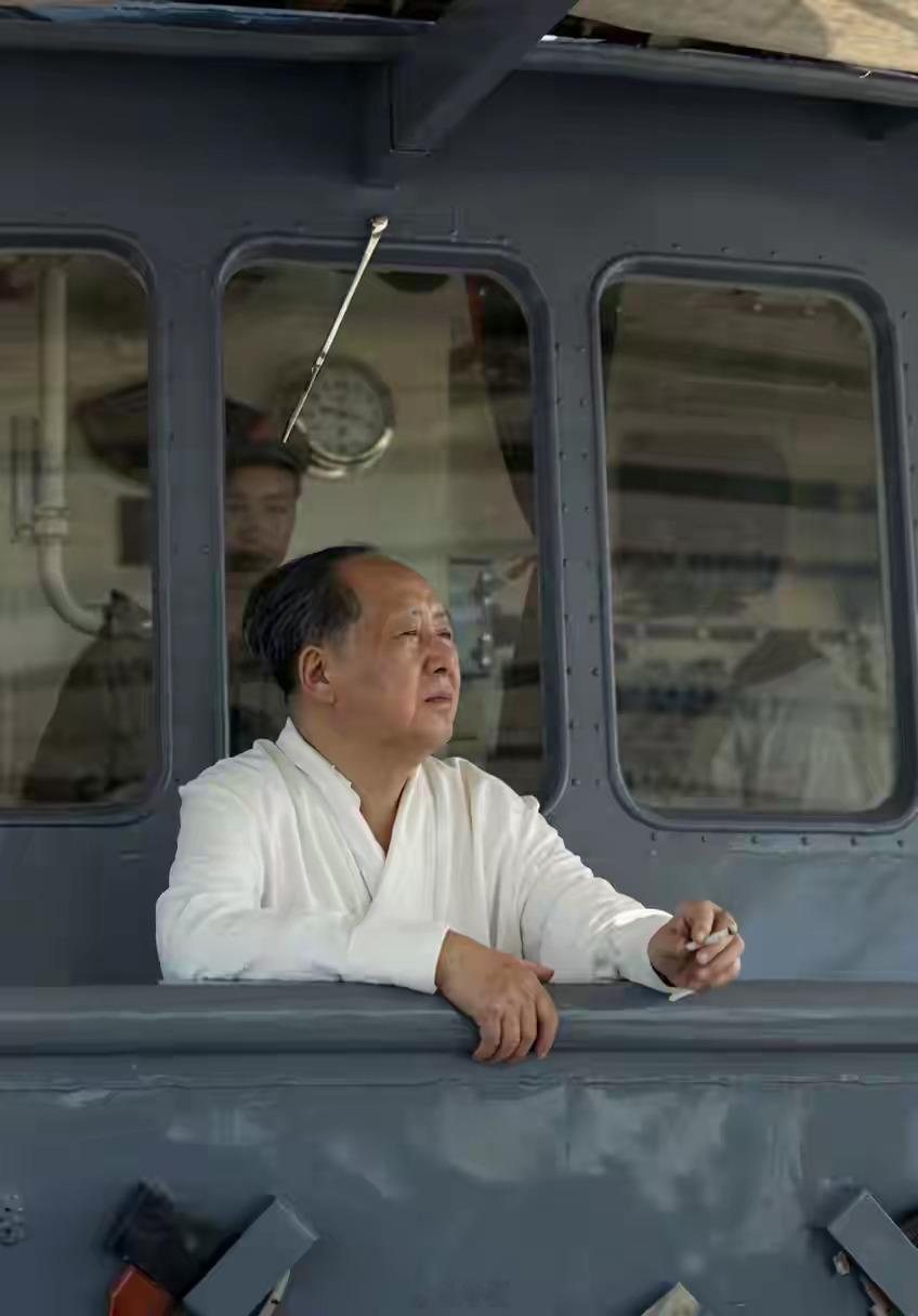 在畅游完长江后，毛主席兴致勃勃的点起根烟，站在汽渡船的舷窗上眺望，这张照片应该很