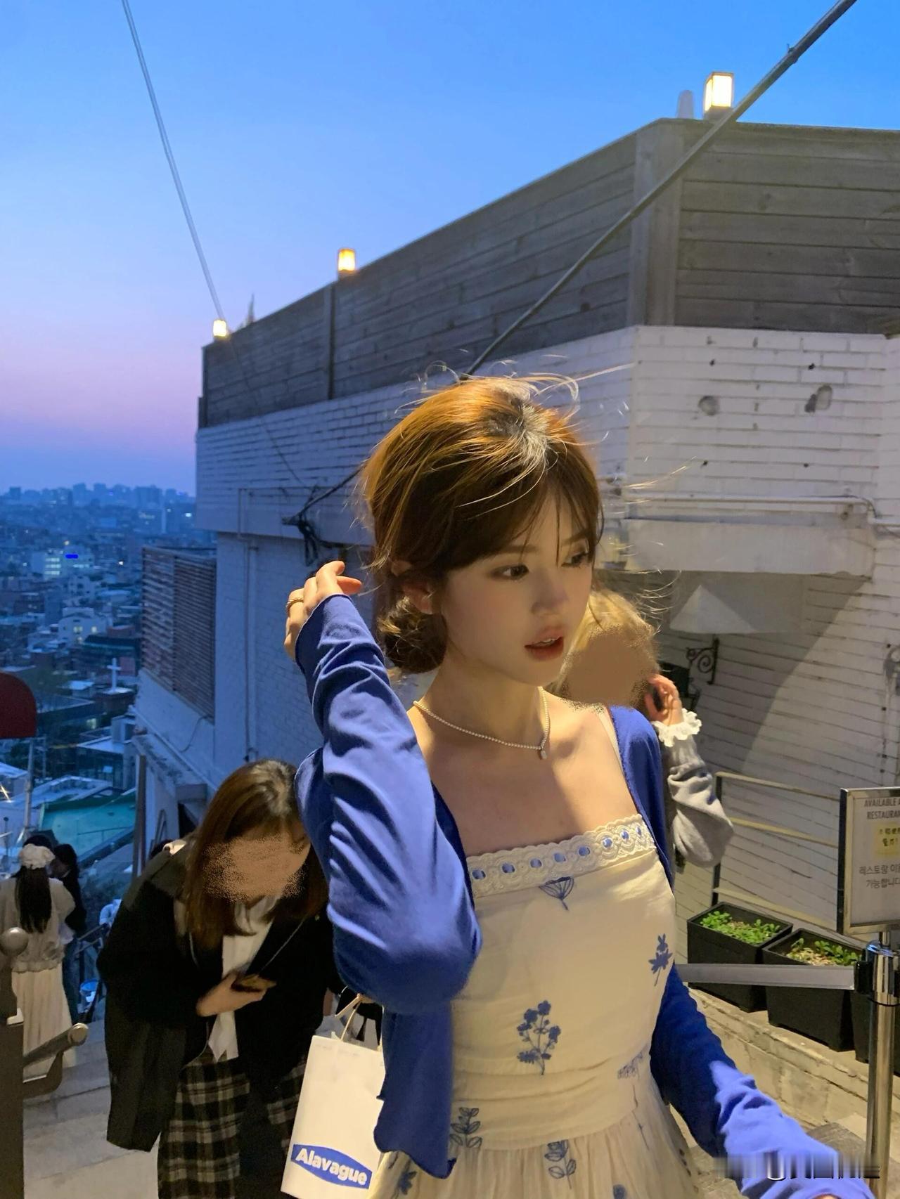 黄昏时分，少女漫步在城市阶梯，享受城市夜景的浪漫。