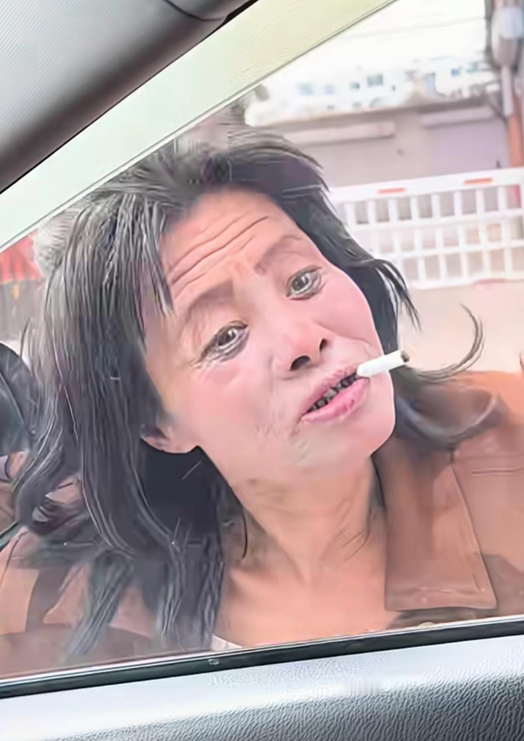 女子开车遇到碰瓷，大妈把自行车往路中间一倒，嘴巴叼着烟，化得跟鬼一样的妆容趴在车