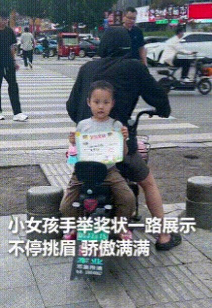 这小孩火到人民日报了，山东菏泽，小女孩拿着奖状一路展示，这自信骄傲满满，所有人都