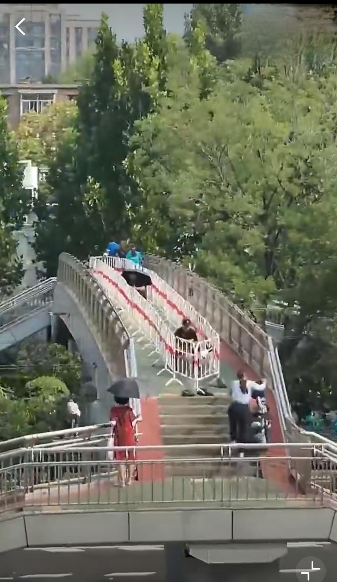 向这座城市的管理学习一座过街天桥，中间围栏圈起，内置两个保安，管理过桥秩序，行