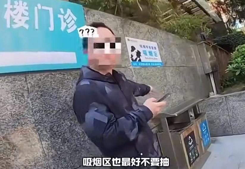 吸烟区不让吸烟？男子在医院门诊贴着吸烟区标志的地方吸烟，被另一名男子上前阻拦，声