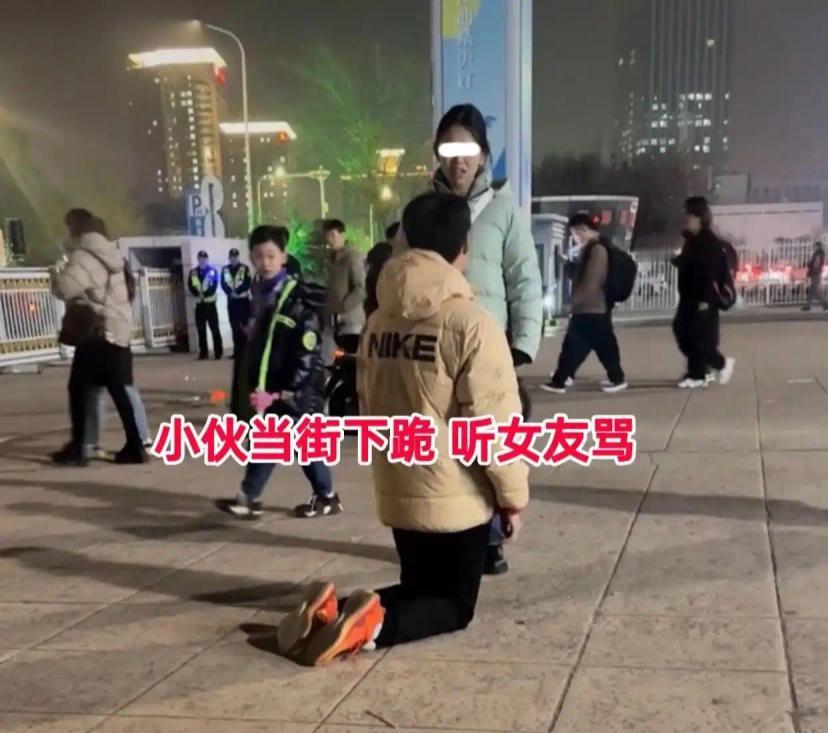 一对小情侣吵架，一米八的小伙直接当街双膝跪地，任由女友当众训斥半天，路人看得直摇
