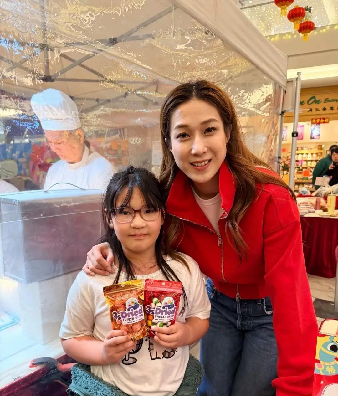 42岁钟嘉欣现身温哥华一家商场卖糖果年货，儿子和女儿陪着她一起卖年货，她态度热情