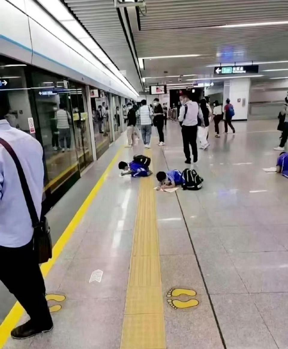 这就有点过于离谱了吧看着也才小学那么大学习压力这么大了吗？等地铁还要趴在地上
