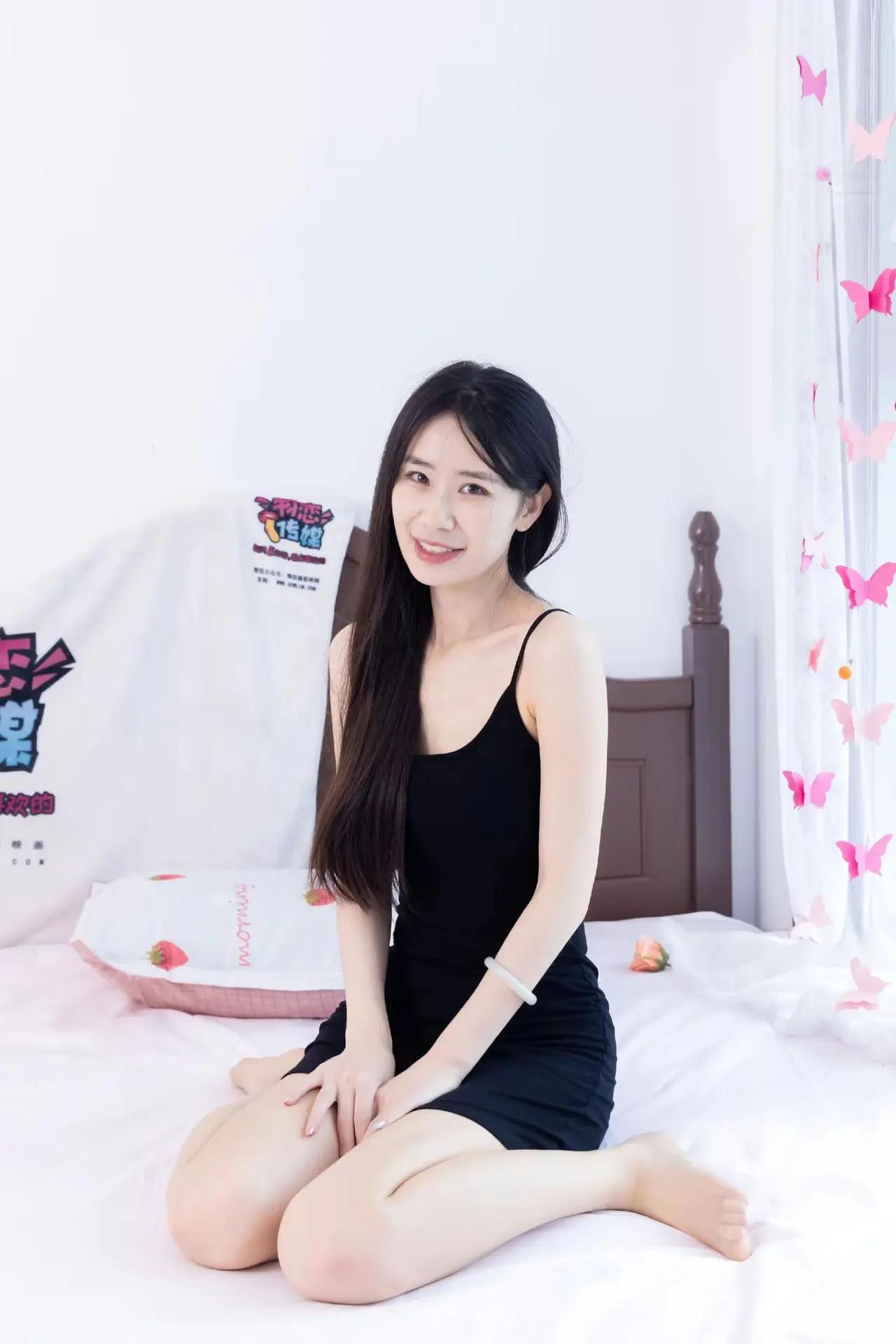 坐在床上的小姐姐，笑容甜美。