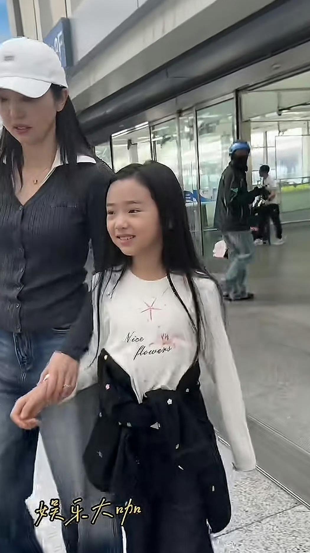 路人冲她喊“当女儿吧”，她没笑，低头牵紧了小酒窝的手。那孩子刚走完上海时装周，