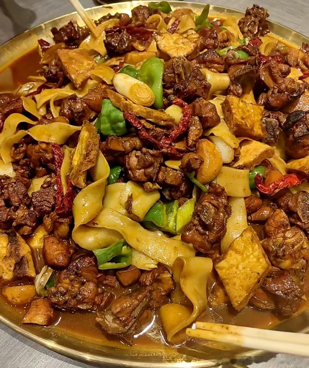 没有人能不被新疆美食拿捏谁能拒绝一份热气腾腾的新疆大盘鸡！大块鸡肉炖得软烂入味，