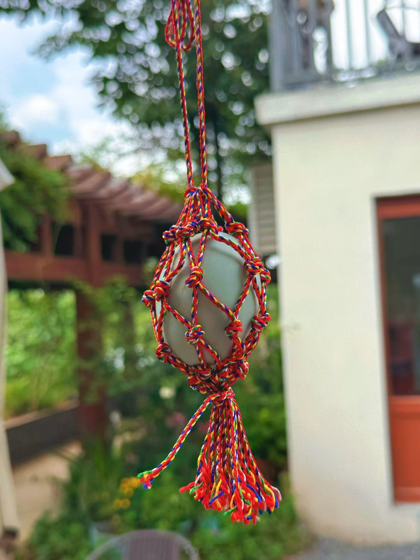 端午节门口摆上艾草和菖蒲，小孩脖子里挂的彩线（主要是红色）编织网兜里有一只煮熟的