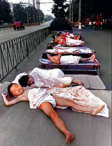 上个世纪90年代的湖北武汉街头，夏天在路边打地铺睡觉的武汉市民。那个时候，中国经