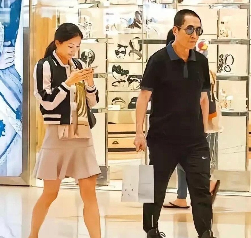 王志文有点懒，走路两只手揣在兜里，也不帮老婆提东西，跟在身后的老婆大包小包的东西