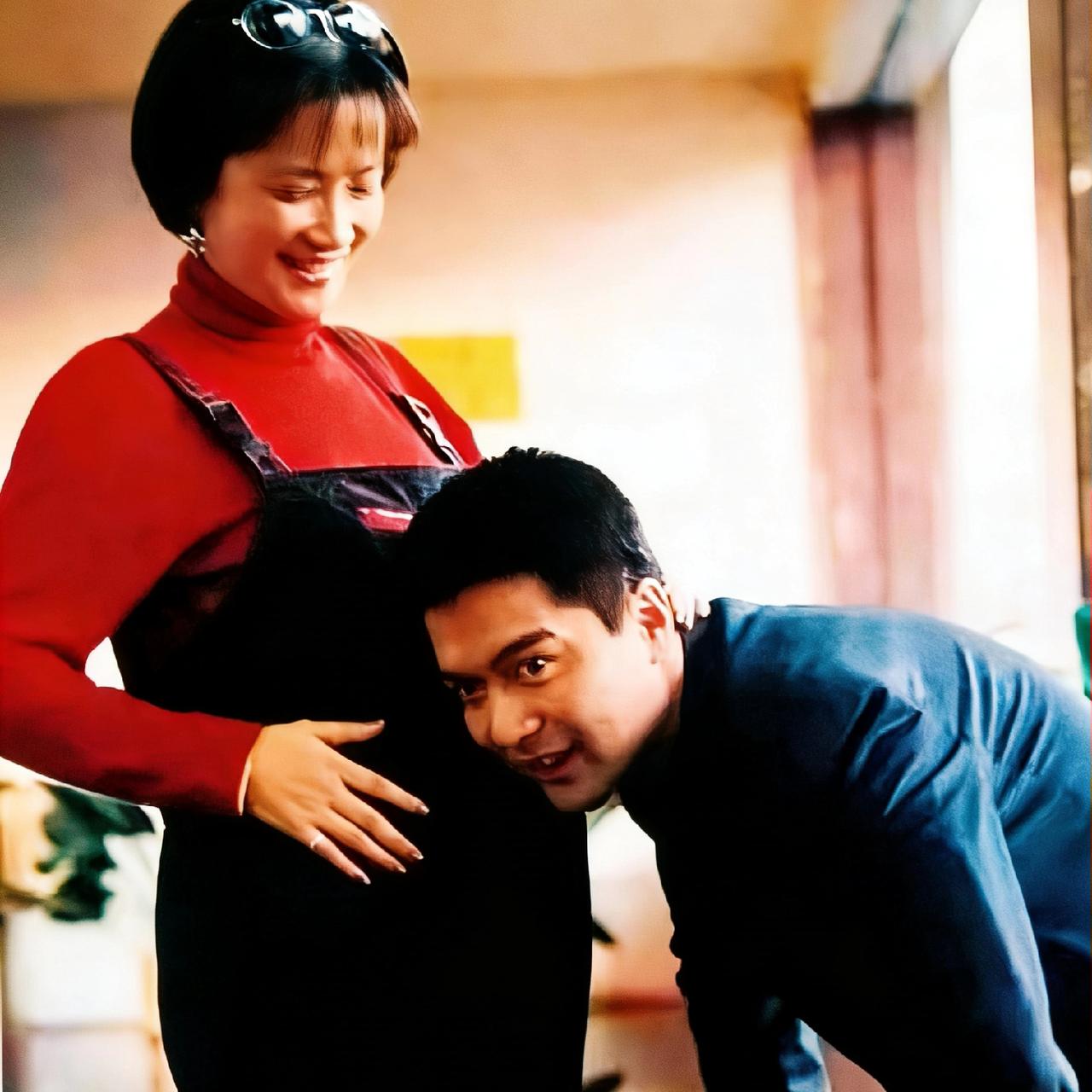 2001年，何晴的孕装照，镜头中的何晴穿着一件背带裤的衣服，挺着大肚子，丈夫许亚