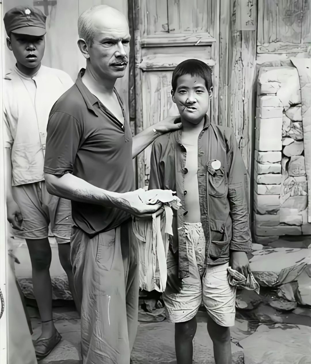 1939年，白求恩给面部中弹的小八路军拆线。随军的摄影师沙飞，拍下了白求恩拆线
