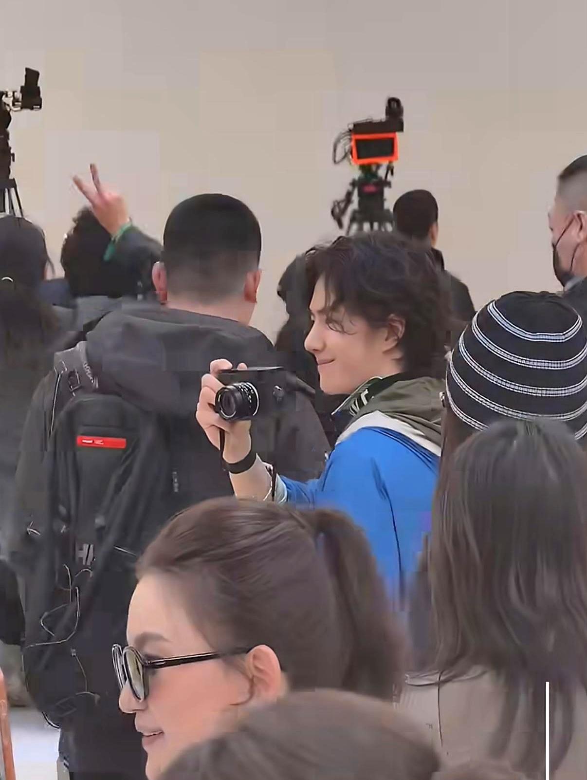 LOEWE大秀散场，王一博蹲拍工作人员欢呼。定制西装的肩线还沾着秀场冷气，他