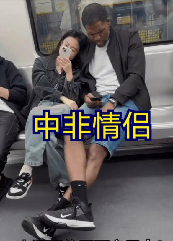 这是网友在地铁上拍到的一对“中非情侣”。女子倚靠在黑人男友身边正在玩手机