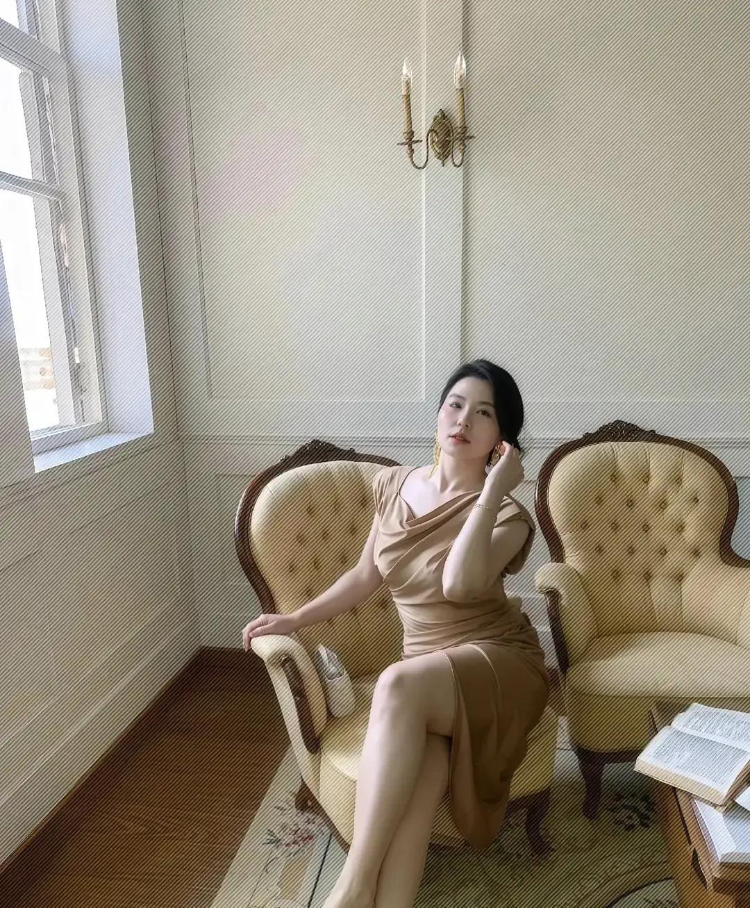 已婚女人，一抬手就赢不是滤镜，是日子把她磨出了光。午后浅驼色裙贴着皮肤，像