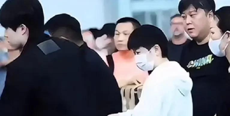 工作人员带大头前面去办手续，大头从莎莎身边经过，不小心脚碰到莎莎的小行李箱的轮子