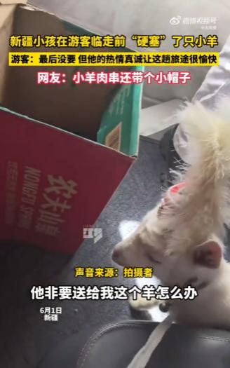 新疆，一女子自驾游时和当地小孩玩了一会儿，临上车前孩子突然把一只戴小花帽的小羊羔