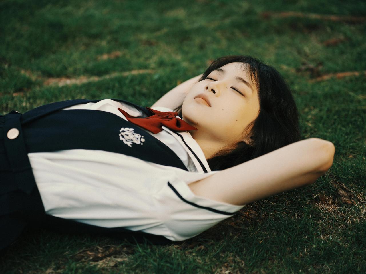 照片的胶片质感为少女遐思主题注入了时光的厚重感，暖黄色调、轻微的颗粒感，少女趴在