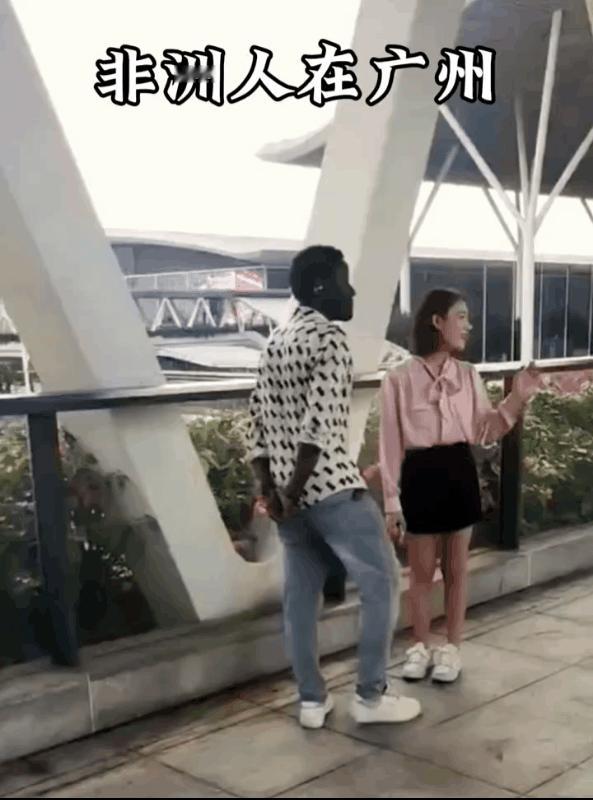 广东广州，一名女子在街头采访一名黑人男子，问他在中国的生活怎么样？喜不喜欢中国？