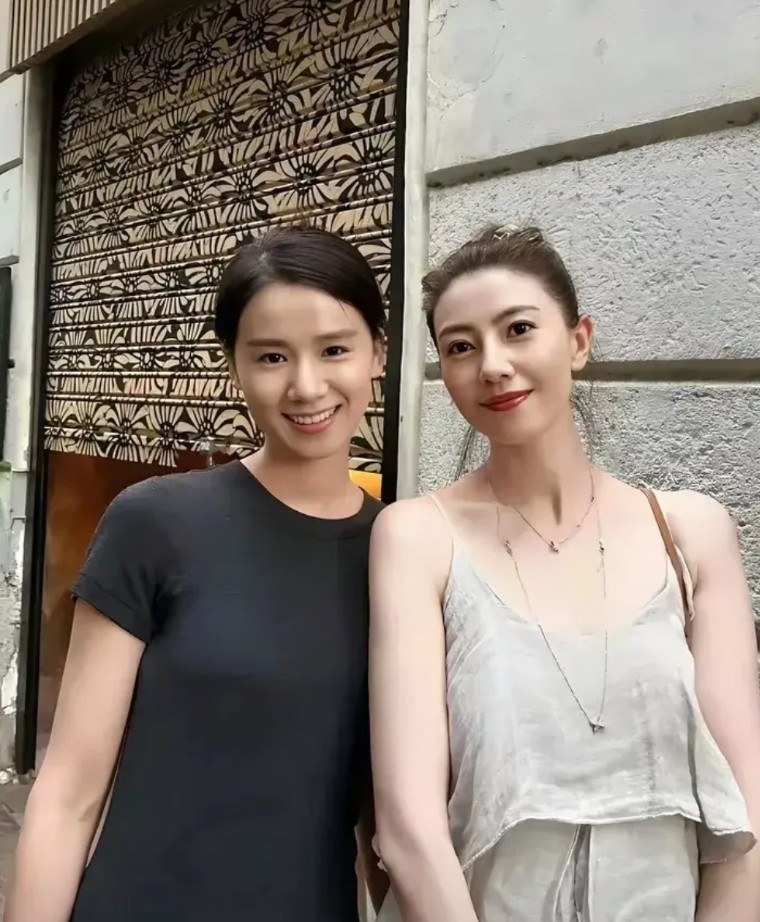 高圆圆在饭店与老板娘合影，很明显老板娘更漂亮啊！良家妇女穿着端庄得体，既不露胸也