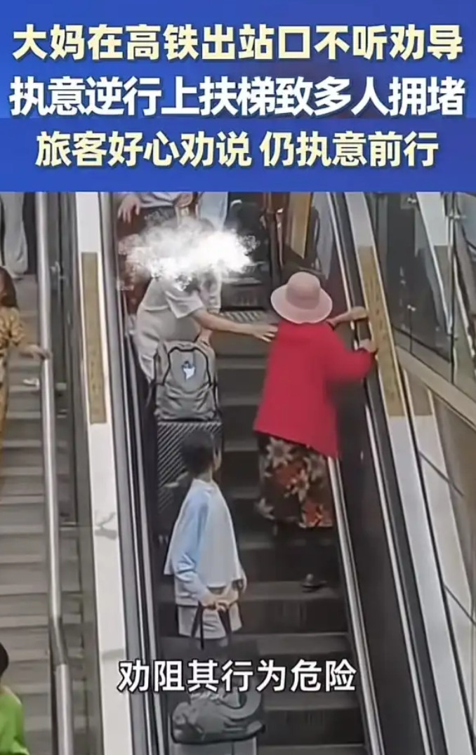 北京，高铁站出口处，一位大妈正从正在下行的自动扶梯上逆向攀爬。旅客好心劝说，大妈