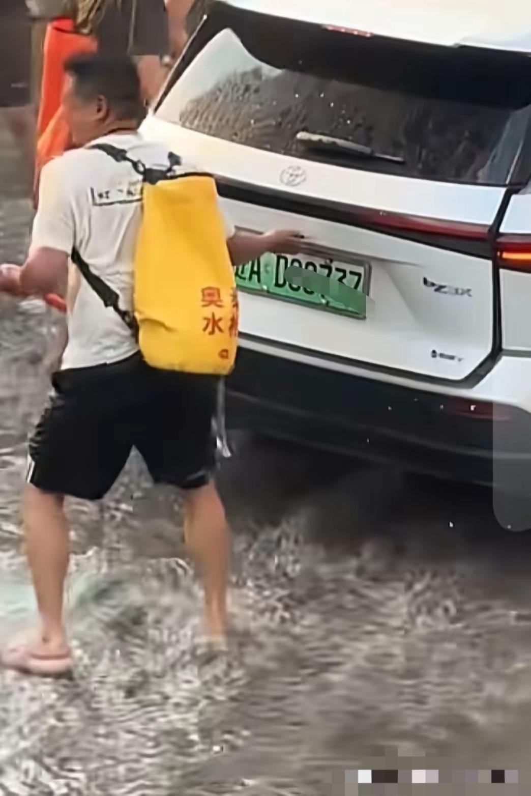 云南泼水节现场，这个扒车门的男子摊上事了！现在白色小车司机表示里面都打湿了，要去