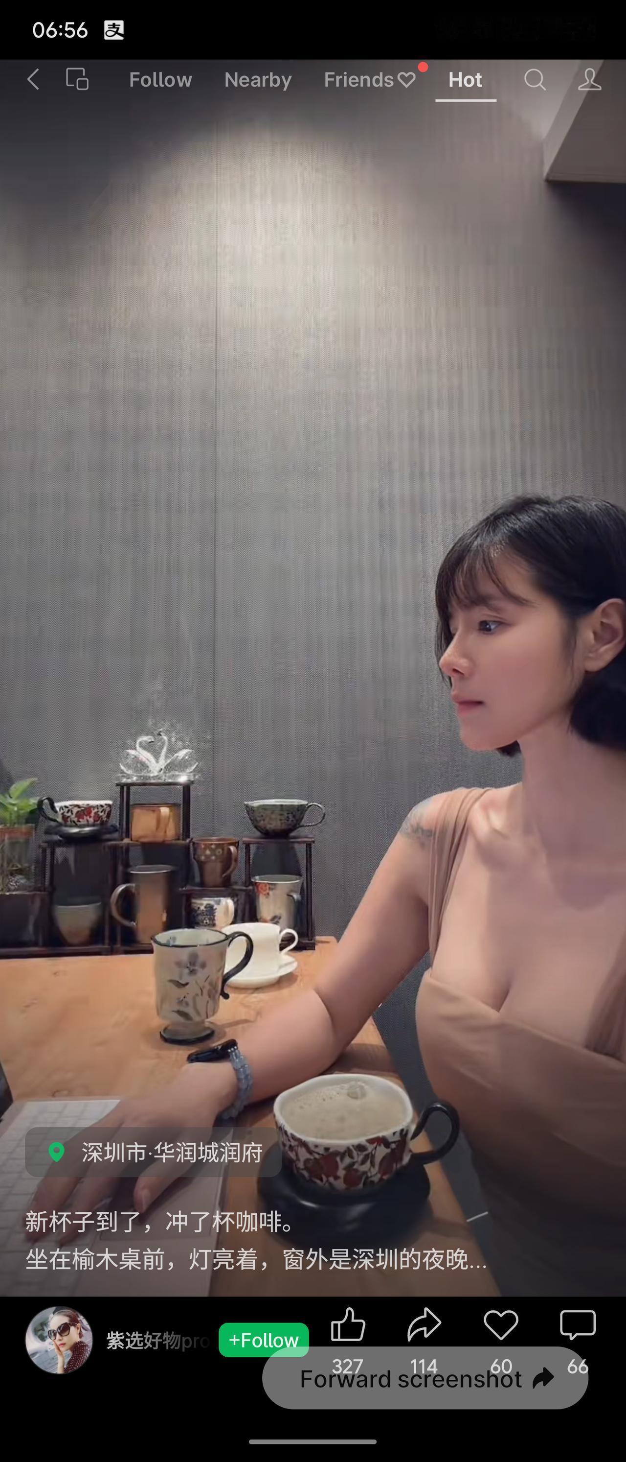柔和射灯铺满房间，原木长桌上陈列各式瓷质咖啡杯。短发女子静坐桌前，浅色系吊带温婉
