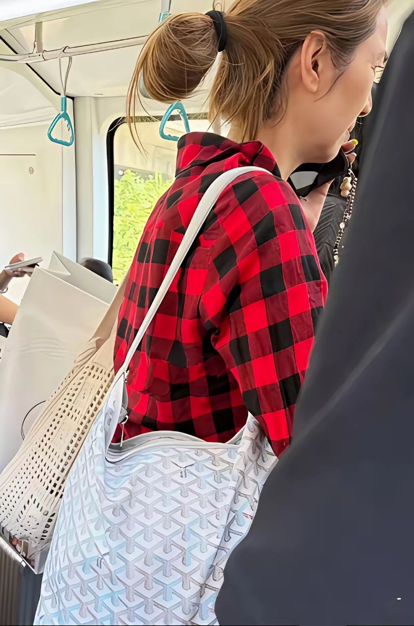 大美女洪欣现身北京独自一人挤公交，她一件红配黑色方格衬衫，背着大包小包，脸部蜡黄