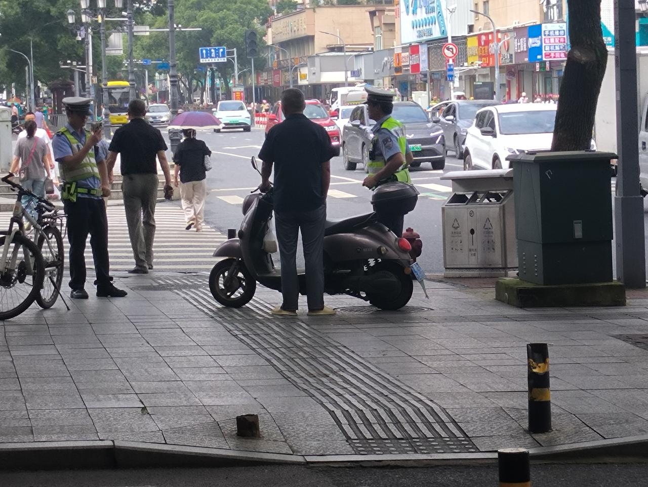 6月25日上午，在九江市柴桑区柴桑大道林业局附近，一位中年男子骑电动车不戴头盔，