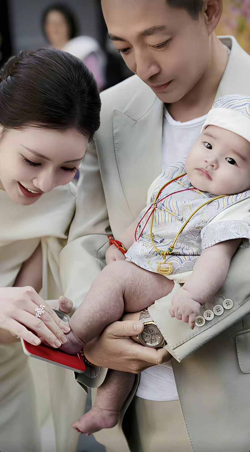 马筱梅的婆婆在孩子百日宴上亲手给宝贝孙子带大金锁，奶奶手握汪宝白白胖胖的大腿，喜