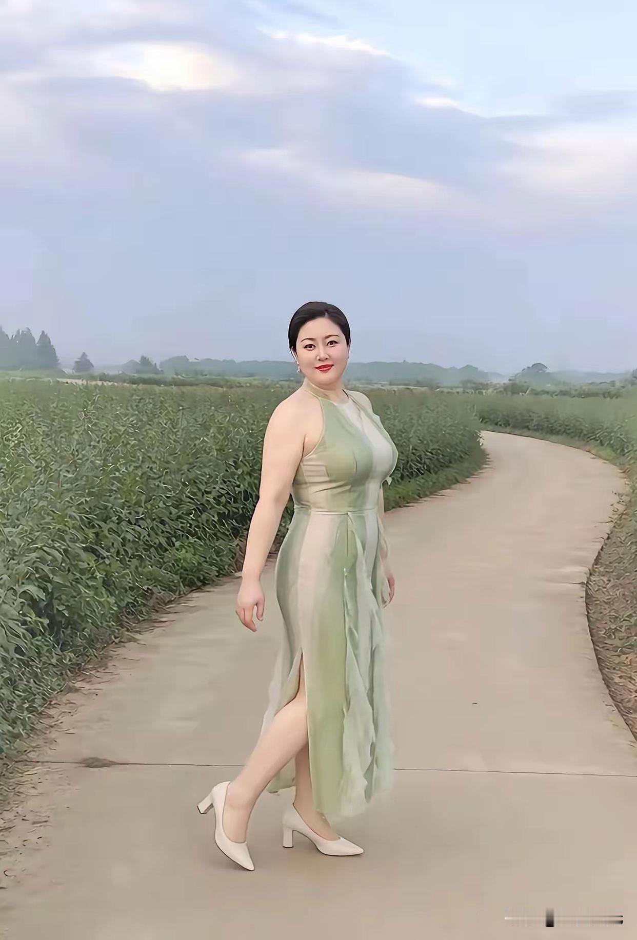 漫步乡间的小路，清风缓缓拂过身旁。一身清雅的浅绿长裙，融于满眼的田园绿意之间。不