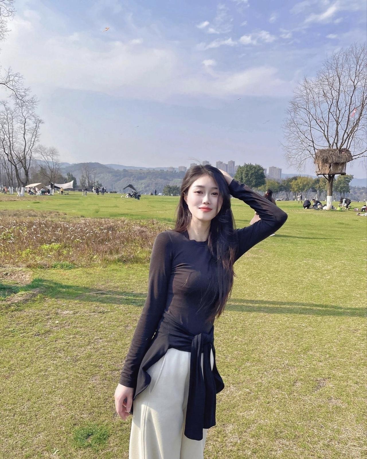 阳光明媚的春日，少女在绿草如茵的公园里，享受着微风拂面的惬意时光。