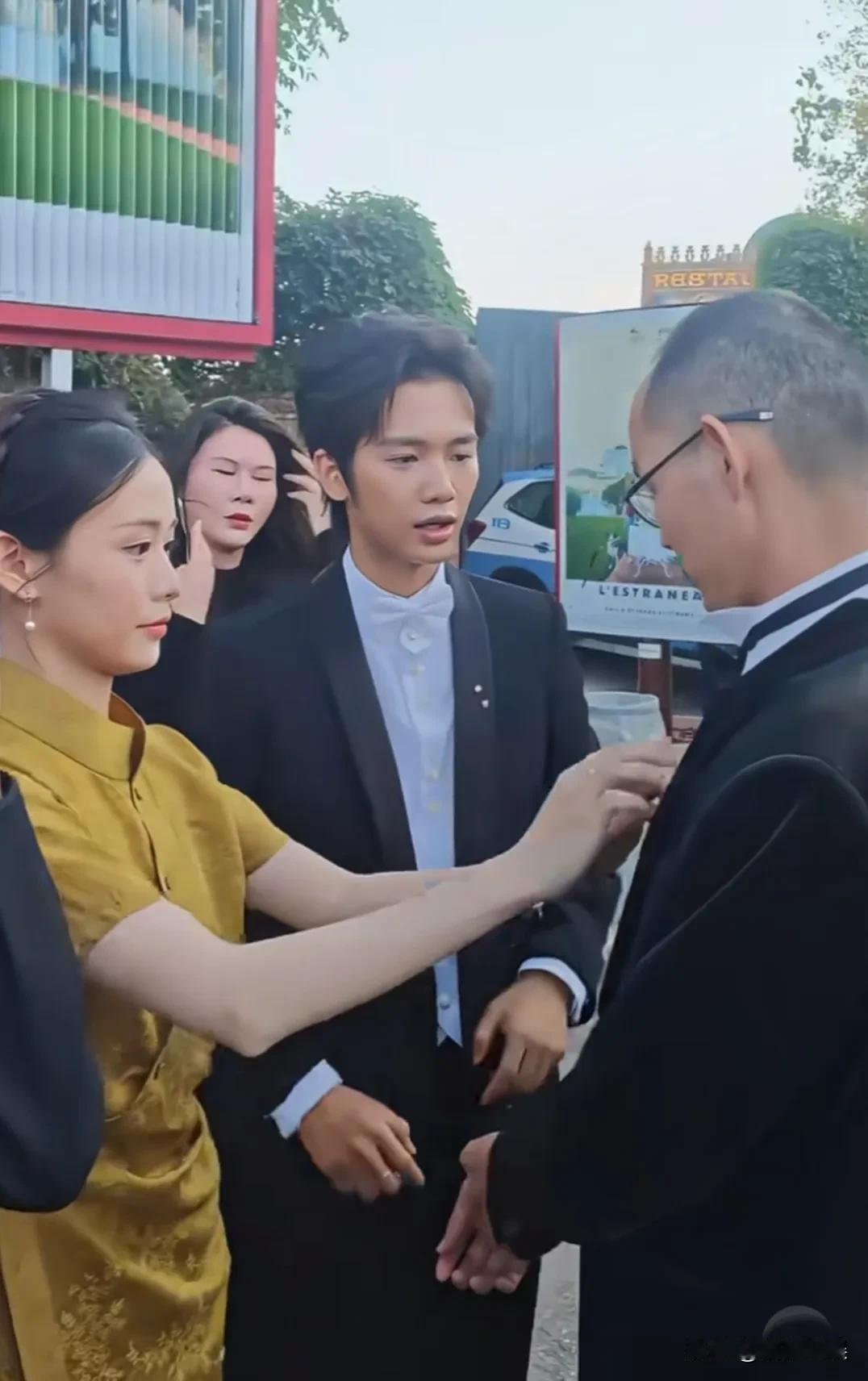 在威尼斯电影节外场，《给阿嬷的情书》剧组里的“淑柔”和“木生”夫妻俩，给蓝导整理