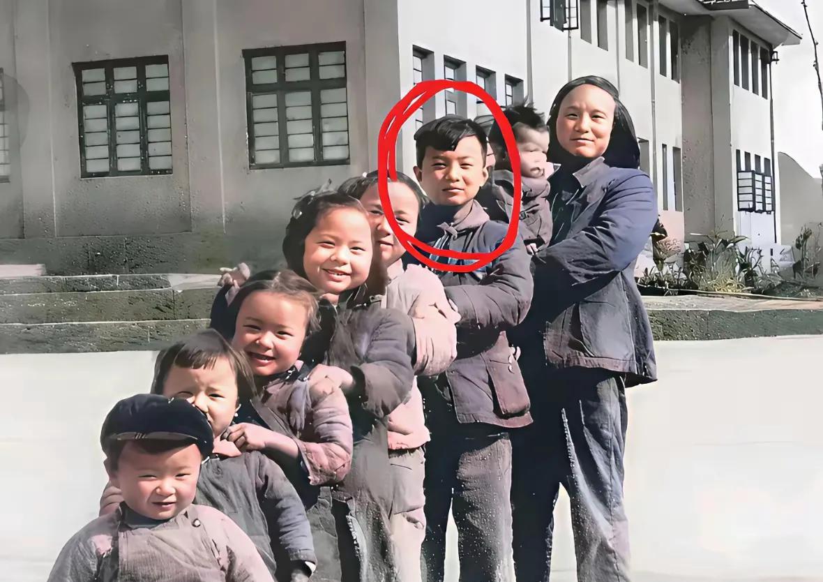 这是任正非母亲与子女们的合影照，他们这一家子孩子是真的多，由矮到高站成一排，怀里