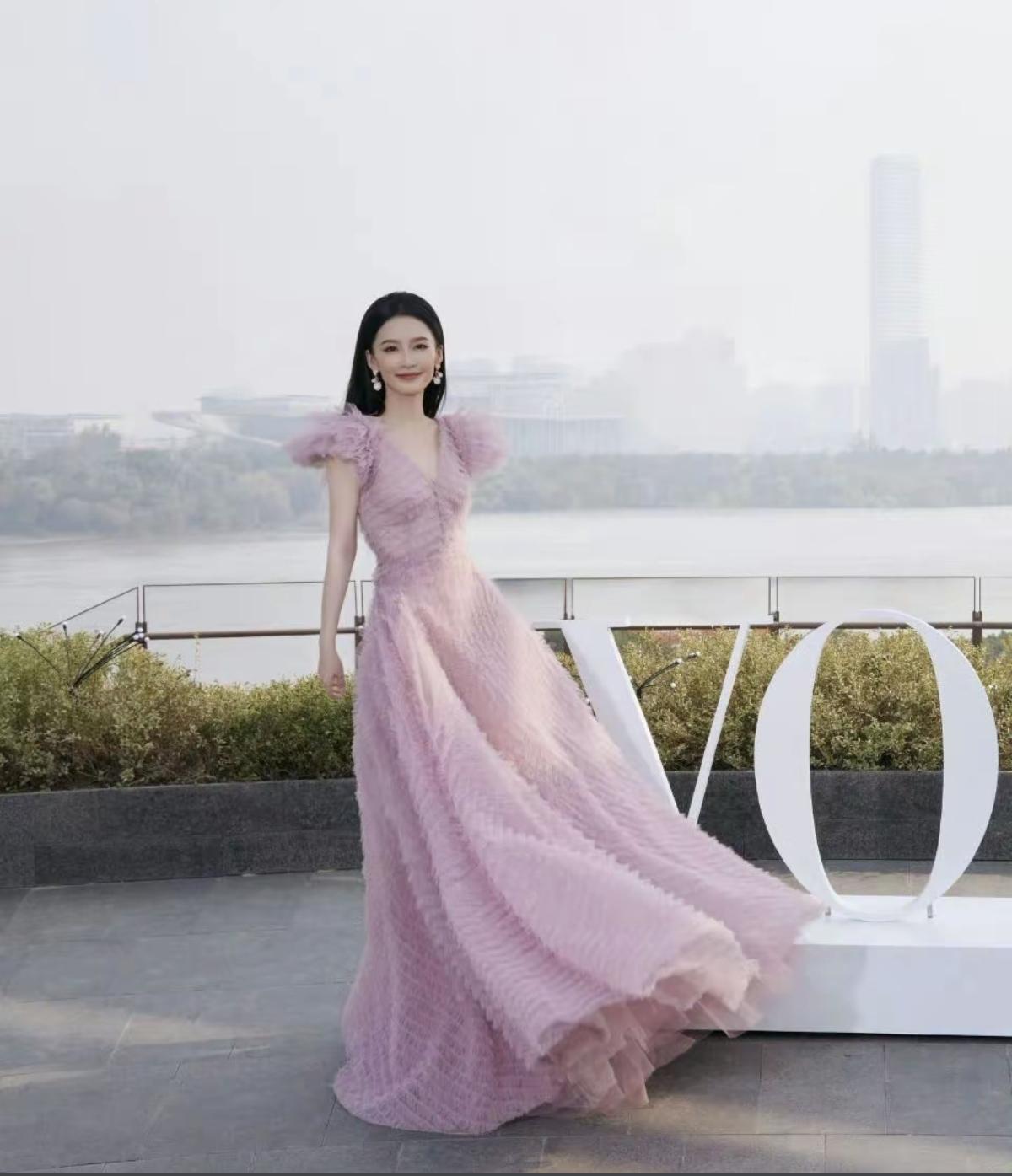 李沁这一袭豆沙粉纱裙，把江南女子的柔婉和都市女性的优雅焊在了身上。江风拂过裙摆的