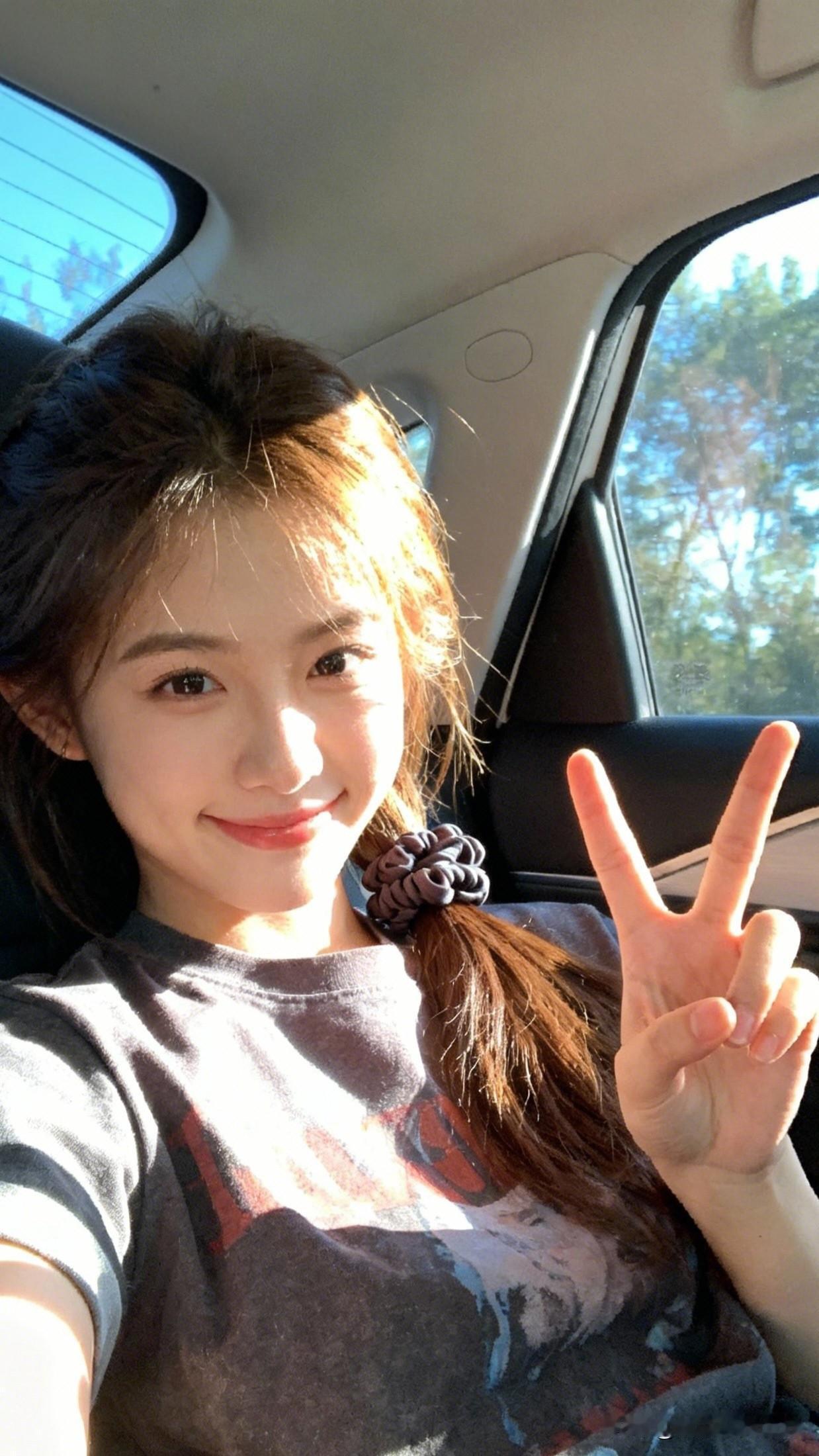 车中少女笑，春风满面来。美少女美景分享阳光明媚的一天，车里的可爱女孩比出胜利手