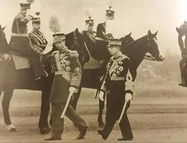 照片中身着军装的两人，左侧是伪满洲国皇帝溥仪，右侧是日本天皇裕仁。​1935