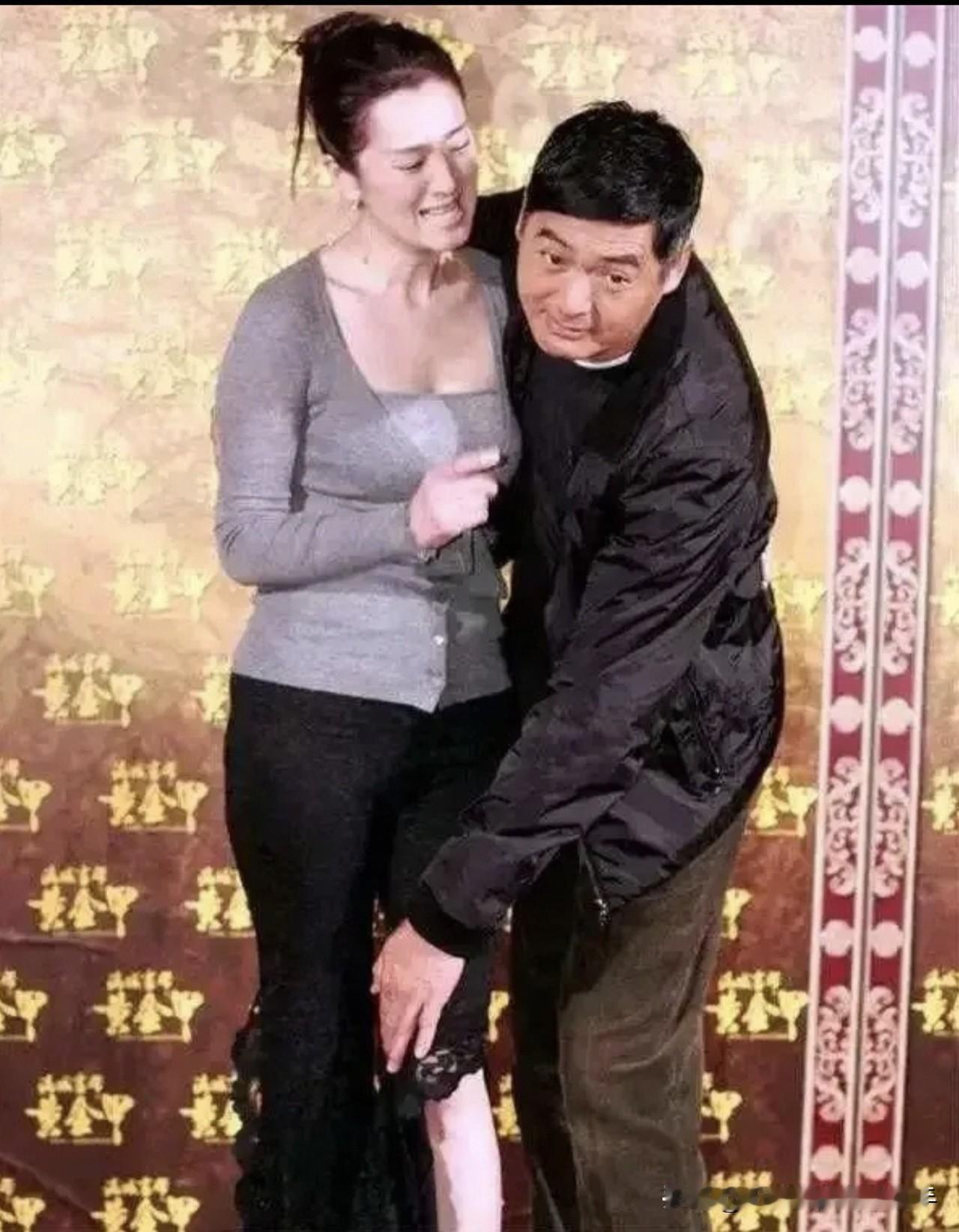 2006年《黄金甲》宣传现场，聚光灯下，巩俐裙摆下落，周润发弯腰帮忙收拾。网友开