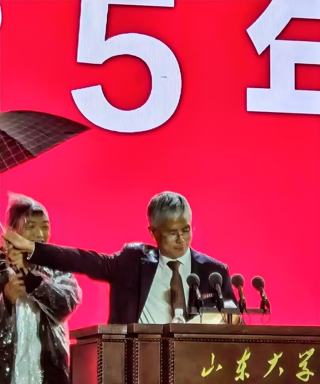 为山大校长撑伞的这位老师，这位老师或许本是出于好意，想在雨中好好表现，为校长撑