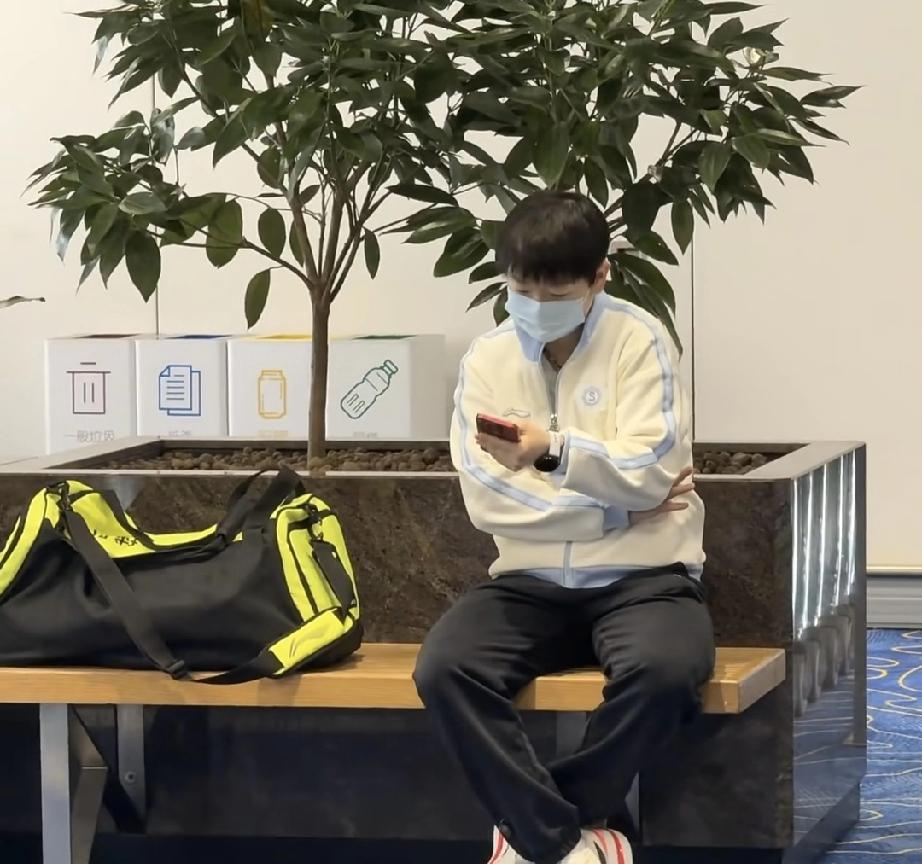 莎莎到香港了，在香港转机国乒要在香港转机，到香港后莎莎在机场候机，坐在长条凳上
