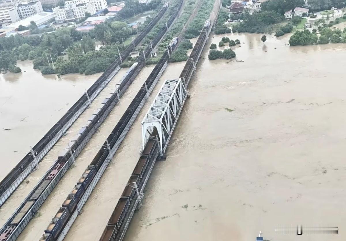 南北铁路大动脉京广线漯河市沙河大桥因大雨泄洪无法通行，列车折返，重车压桥。8月