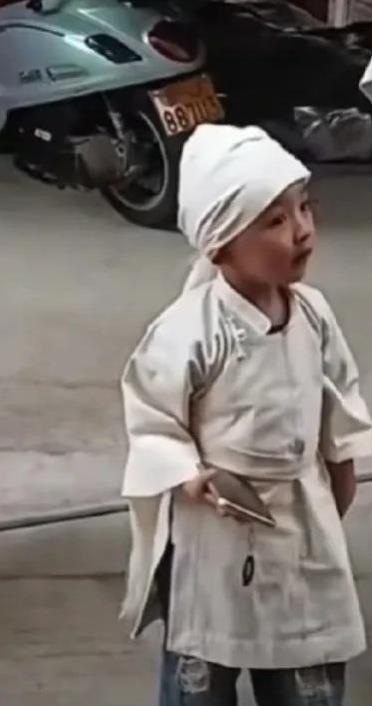 妈妈因病去世，三岁多的儿子还不知道死亡的意义，身穿重孝的他还吵着要玩手机，为了不