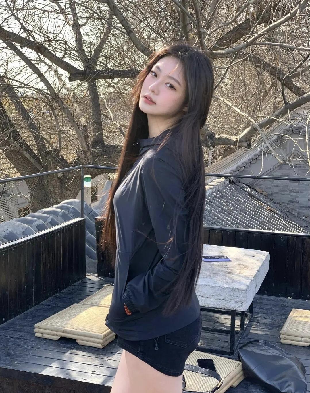 在老胡同的屋顶邂逅冬日暖阳，全黑穿搭裹着随性的松弛，让斑驳树影与青砖灰瓦，定格这