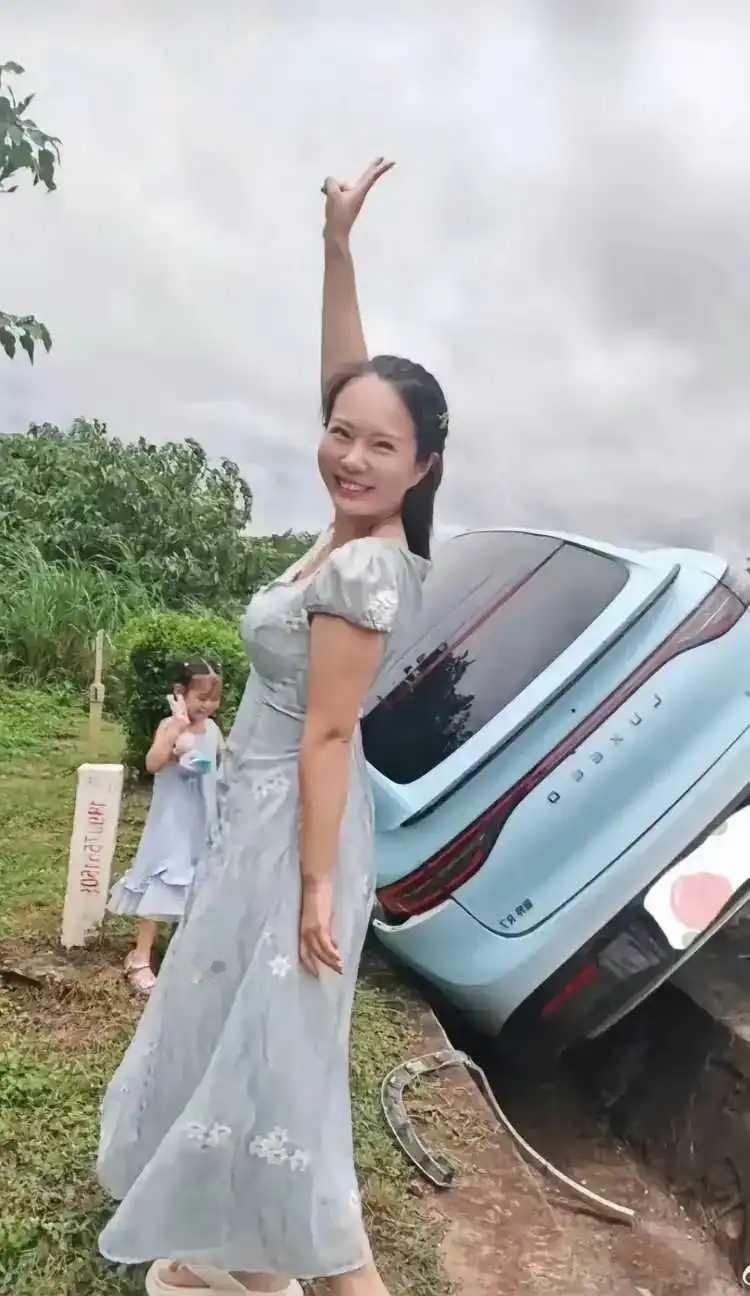 女司机开车。车掉到沟里不要紧，咱得先来张自拍。耶！亮个相，你就说咱美不美？